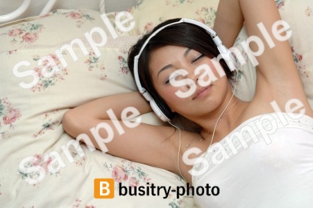 音楽を聴きながら寝る女性