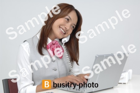 電話をしながらパソコンをする女性