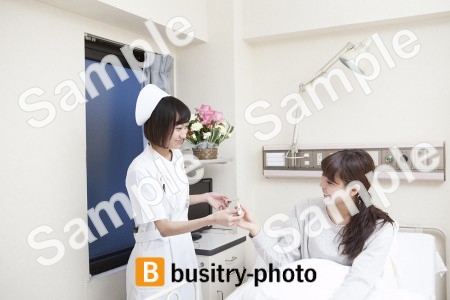 女性患者に体温計を渡す看護師