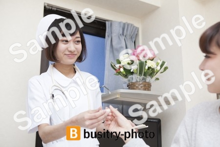 女性患者と体温計を渡す看護師