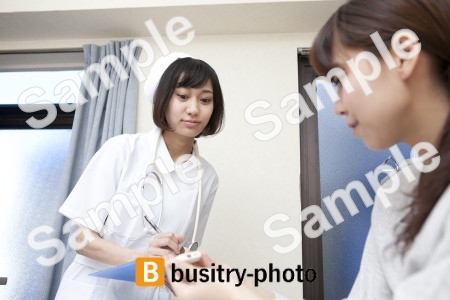 体温計を見る女性患者と看護師