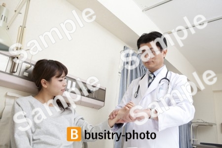 女性患者の脈を測る医師