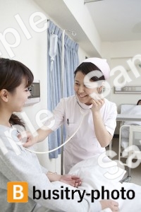 女性患者に聴診器を使う看護師