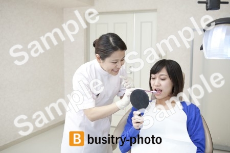 女性患者の歯を磨く歯科助手