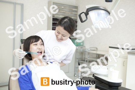女性患者の歯を磨く歯科助手