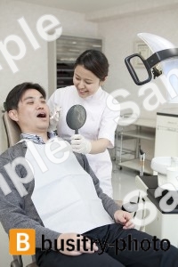 男性患者の歯を磨く歯科助手