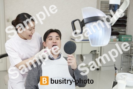 男性患者の歯を磨く歯科助手