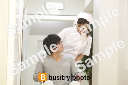 男性患者の車椅子を押す看護師